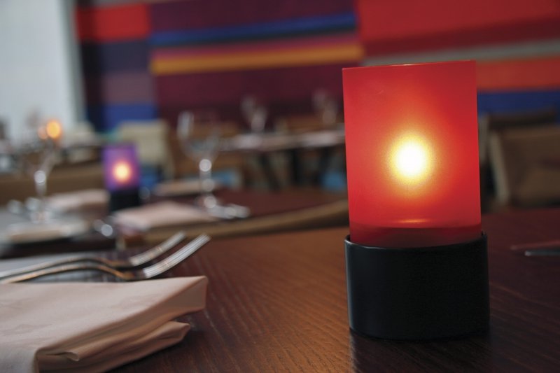 photophore rouge dans un restaurant, avec une bougie à huile